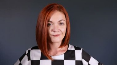 Kameraya bakarak merakla şık Kızıl saçlı kadın.