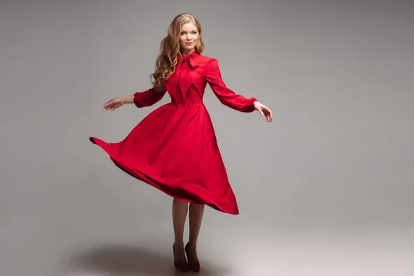 Modelo magro impressionante em vestido vermelho brilhante e saltos pretos . — Fotografia de Stock