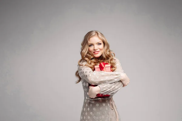 Mulher loira bonita em vestido elegante e saltos com pilha de presentes . — Fotografia de Stock