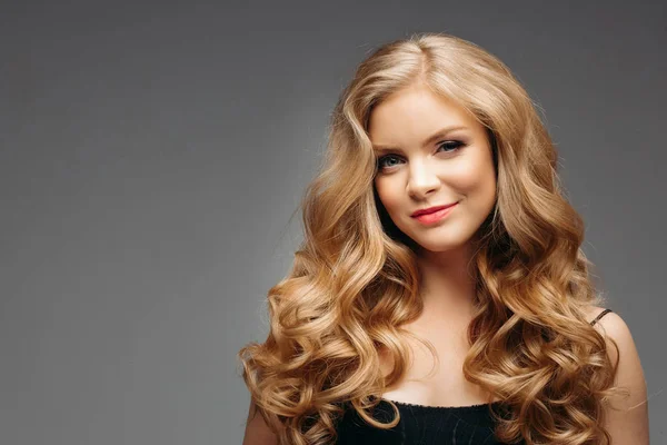 Retrato de la maravillosa joven rubia con el pelo largo mirando a la cámara, sonriendo — Foto de Stock