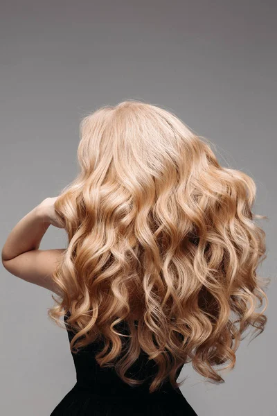 Retrato de bela jovem loira com cabelo ondulado longo. Visão traseira — Fotografia de Stock