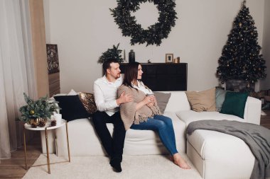 Elinde çay bardak ile kanepede oturan çift.