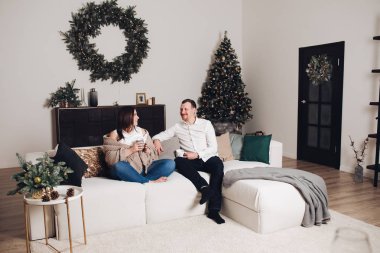 Elinde çay bardak ile kanepede oturan çift.