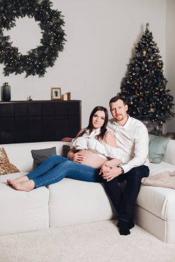 Elinde çay bardak ile kanepede oturan çift.