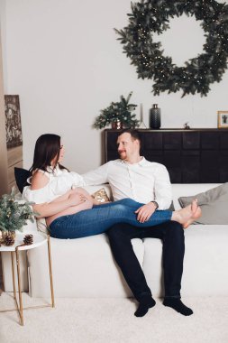 Elinde çay bardak ile kanepede oturan çift.