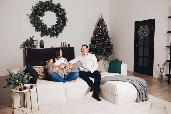 Elinde çay bardak ile kanepede oturan çift.