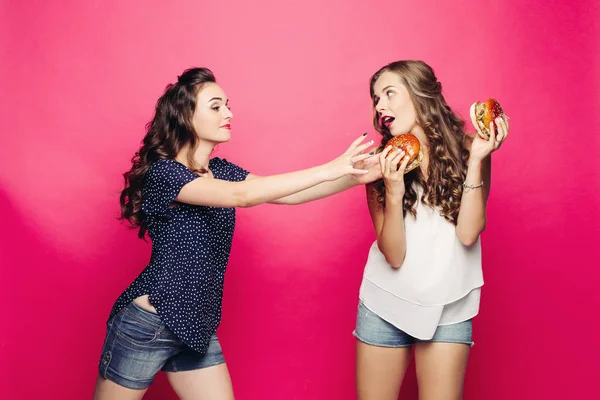 Zwei hübsche und hungrige Mädchen wollen zwei große Hamburger. — Stockfoto