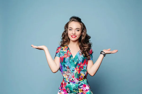 Mujer bastante feliz en vestido demostrando dos objetos . —  Fotos de Stock