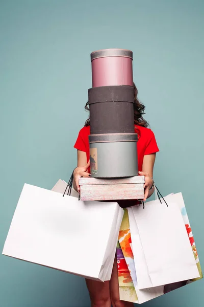 Inkognito Brünette hält nach dem Einkauf Taschen und Schachteln in der Hand. — Stockfoto