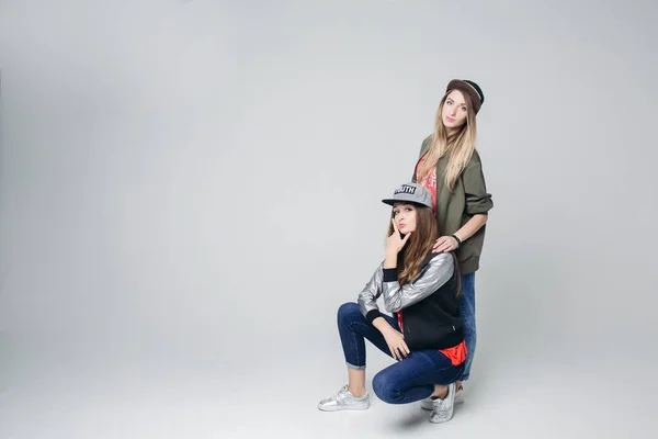 Swag Freundinnen Hipster in stylischer Kleidung und Mützen auf dem Kopf. — Stockfoto
