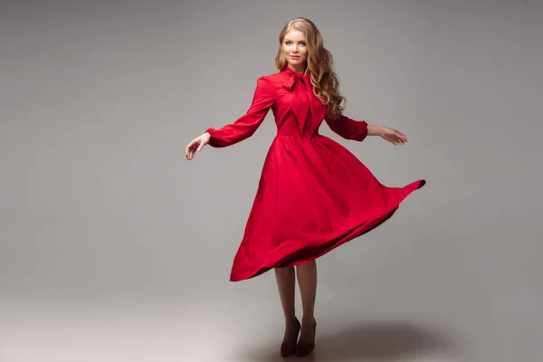 Impresionante modelo delgado en vestido rojo brillante y tacones negros . —  Fotos de Stock