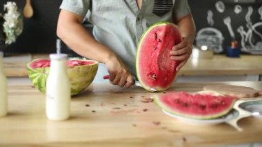 Elinde erkek holding ve sulu karpuz kesme modern mutfak.