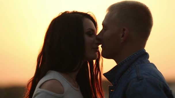 Hermosa pareja mirándose cara a cara y besándose al atardecer . — Vídeos de Stock