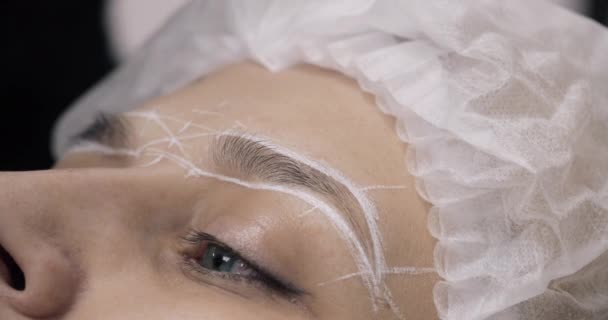 Model in hat with drawn marks before permanent make-up. — Stock Video