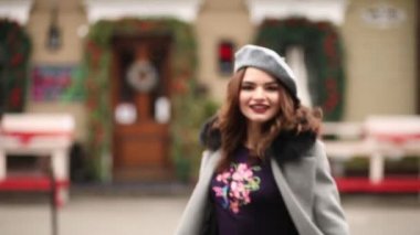 Güzel kız gri ceket ve Noel Mağazaları doğru yürüyüş bere.