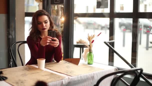 Senhora na moda em vermelho usando telefone celular no café . — Vídeo de Stock