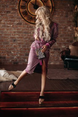 Bir kenara seyir ve poz pembe elbiseli sarışın önden görünümü