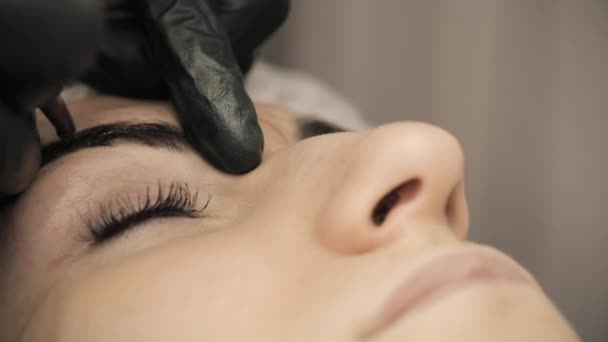 Procedimento de Microblading. Maquiagem permanente. Cosmetologist, aplicando a tatuagem permanente da sobrancelha em um salão de beleza . — Vídeo de Stock