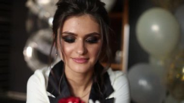 Güzel ve şık kadın kırmızı konfeti kameraya eller tarafından üfleme..
