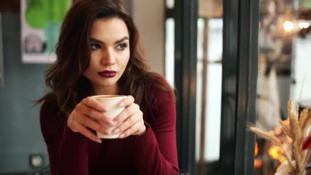 Brunetka kobieta picia kawy w kawiarni. — Wideo stockowe