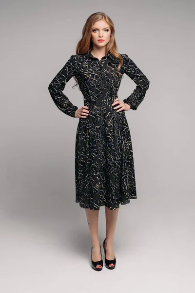 회색 절연 배경에 포즈 긴 검은 드레스 여자 — 스톡 사진