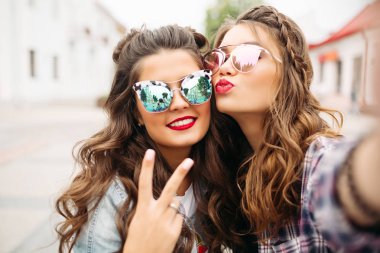 Güzel esmer kız saç modeli, yansıtılmış güneş gözlüğü ve kırmızı dudaklar selfie ördek yüz ile yapma.