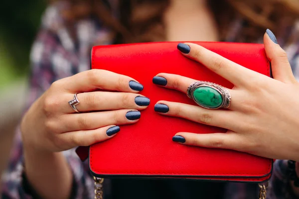 Mulher irreconhecível com unhas escuras segurando bolsa vermelha . — Fotografia de Stock