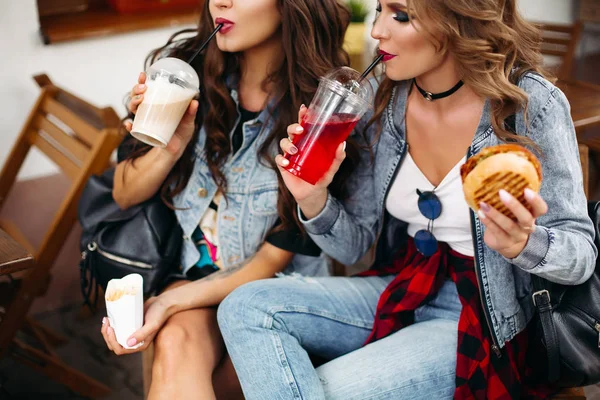 Gorgeous teenagers drinking lemonade and eating fast food — Stock Photo, Image