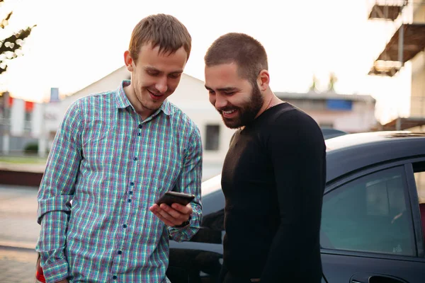 Men in the street using cell phone.