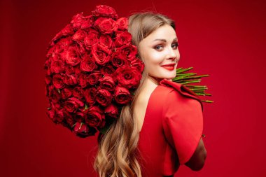 Güzel genç esmer Bayan omuz üzerinde kırmızı gül demet kırmızı.