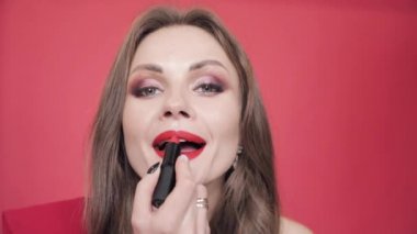 Kırmızı ruj tutarak ve ona makyaj bitirme genç kız.