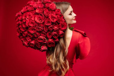 Güzel genç esmer Bayan omuz üzerinde kırmızı gül demet kırmızı.