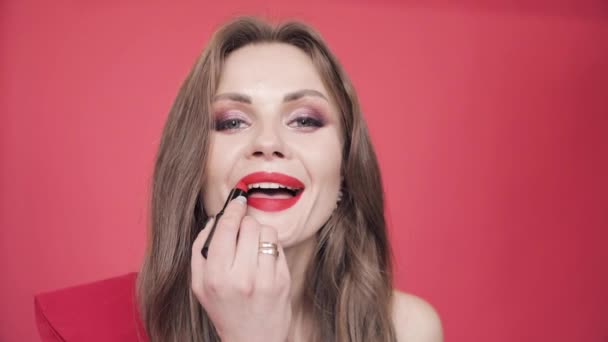 Jong meisje houdt van rode lippenstift en afwerking van haar make-up. — Stockvideo