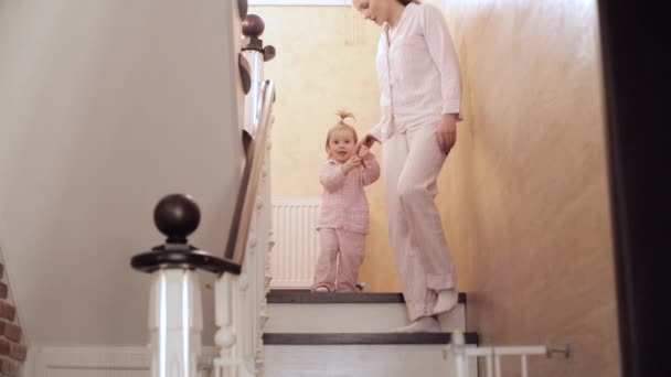 Zorgzame moeder gaan met dochtertje beneden thuis — Stockvideo