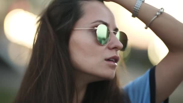 Belle fille brune hipster aux cheveux longs en lunettes de soleil miroitées . — Video