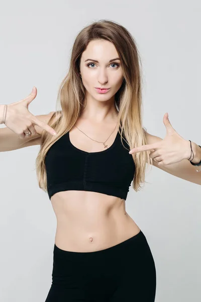 Positivity sporty girl pointing by finger on black top. — Stock Photo, Image