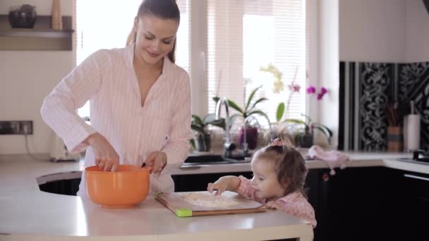 Madre cocinando junto con su hija pequeña en la cocina — Vídeo de stock