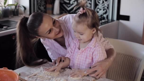 Mãe cozinha em conjunto com a pequena filha na cozinha — Vídeo de Stock