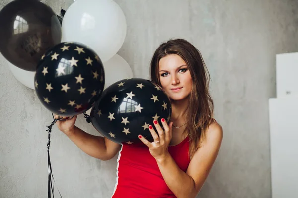 Modèle charmant en robe rouge posant avec des ballons . — Photo