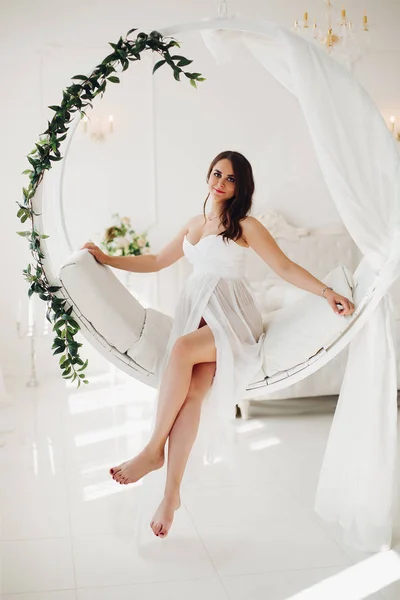 Splendida donna incinta in abito bianco sulla sedia progettata . — Foto Stock