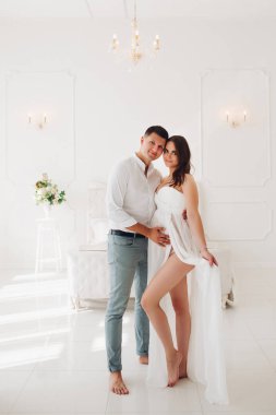 Güzel beyaz elbiseli hamile kadın tarafındaki görüntülemek