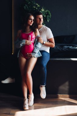 Mutlu aile bekleyen bebek gülümseyen ve kameraya poz.