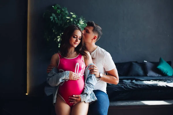 Felice famiglia sorridente in attesa del bambino e in posa alla fotocamera . — Foto Stock