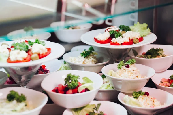 Många runda plattor med goda grönsaker skålen med sallader i restaurang. — Stockfoto