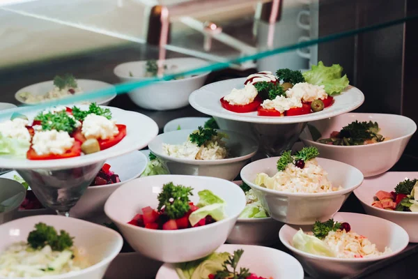 Många runda plattor med goda grönsaker skålen med sallader i restaurang. — Stockfoto