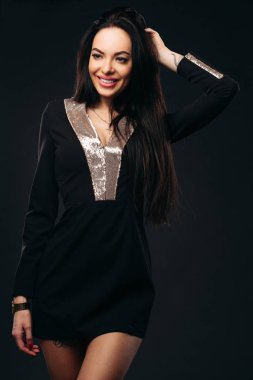 Siyah ve altın elbiseli güzellik gülüyor.
