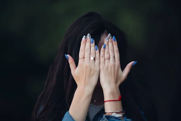 Girl with gorgeous dark long hair hiding face by arms. — Stock Photo, Image