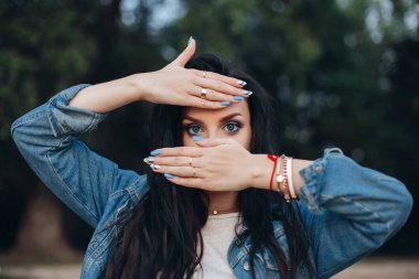 Güzel Bayan mavi ve beyaz çivi ile el arkasına saklanmış.