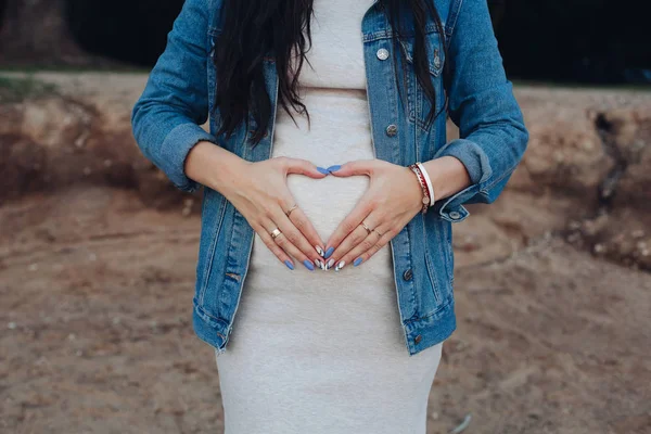 Femeia elegantă în blugi jachetă care ține palmele pe burtă . — Fotografie, imagine de stoc