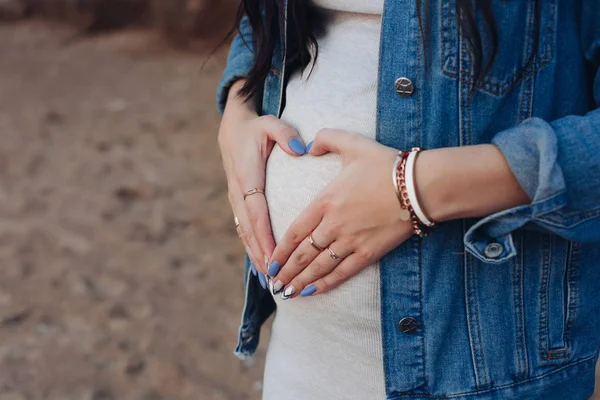 Femeia elegantă în blugi jachetă care ține palmele pe burtă . — Fotografie, imagine de stoc